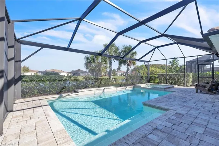 View of pool featuring a sunroom, a lanai, a patio, and a pool with connected hot tub