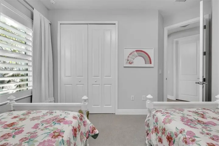 Bedroom featuring light carpet and a closet