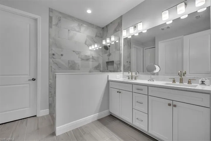 Full bath featuring double vanity and walk in shower