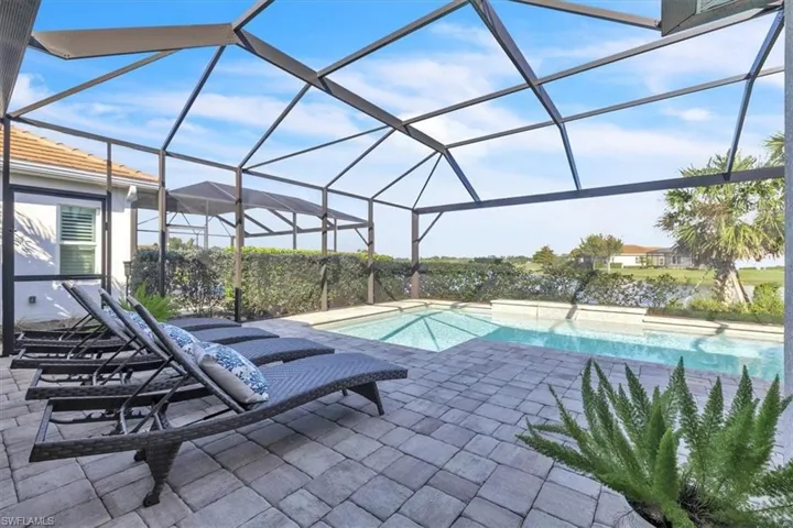 Swimming pool featuring a lanai, a sunroom, and a patio area