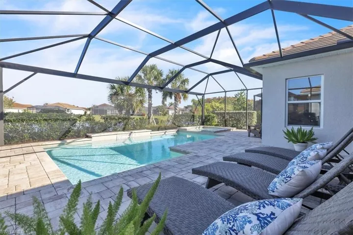 View of pool with a patio area, a sunroom, glass enclosure, and a pool with connected hot tub