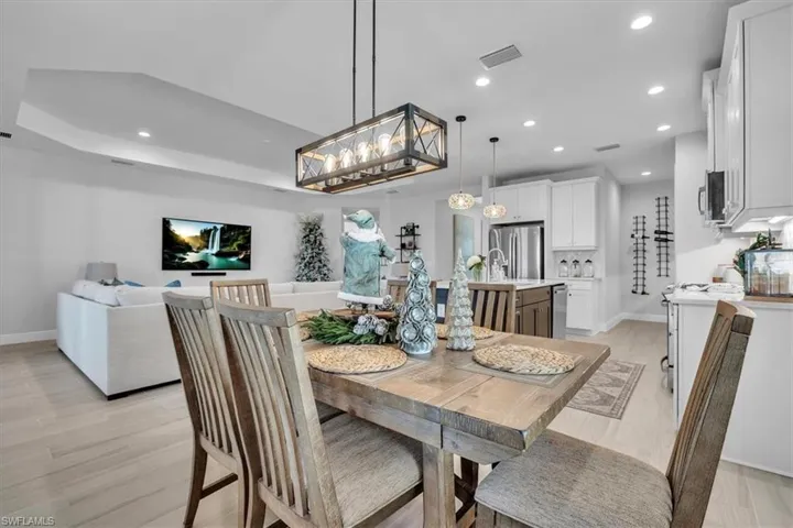 Dining area with recessed lighting, a chandelier, and light wood finished floors