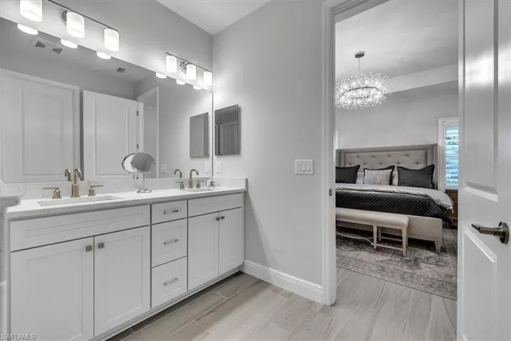 Full bathroom featuring double vanity, a chandelier, and ensuite bathroom