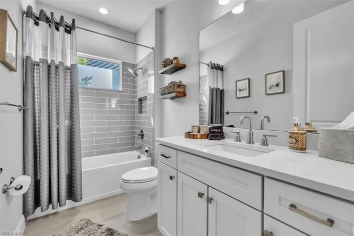 Bathroom featuring shower / bath combo, vanity, and wood finish floors