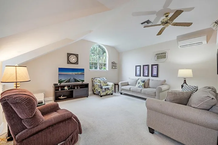 room featuring carpet floors, vaulted ceiling, a ceiling fan