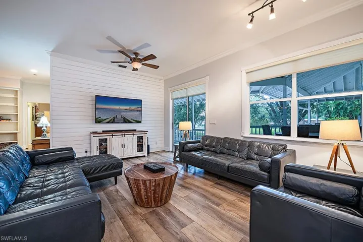 Living room featuring ornamental molding, hardwood / wood-style floors, and ceiling fan