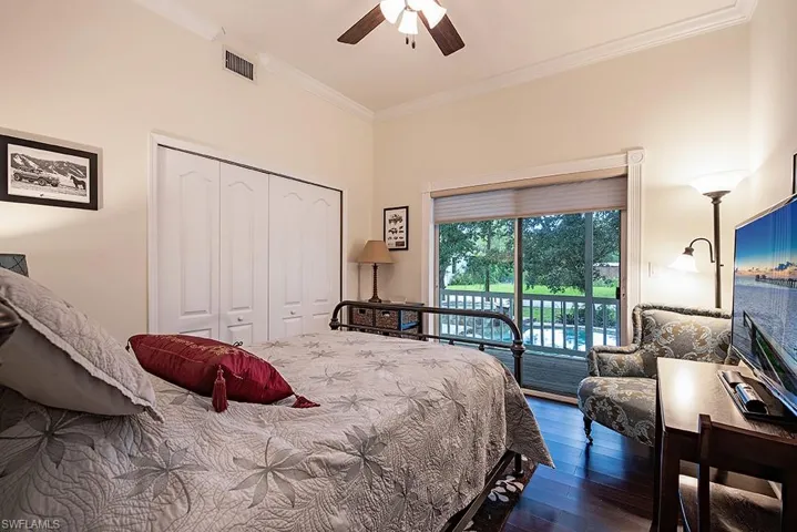 Guest Bedroom featuring ornamental molding, dark wood-style flooring, access to outside, a closet, and a ceiling fan