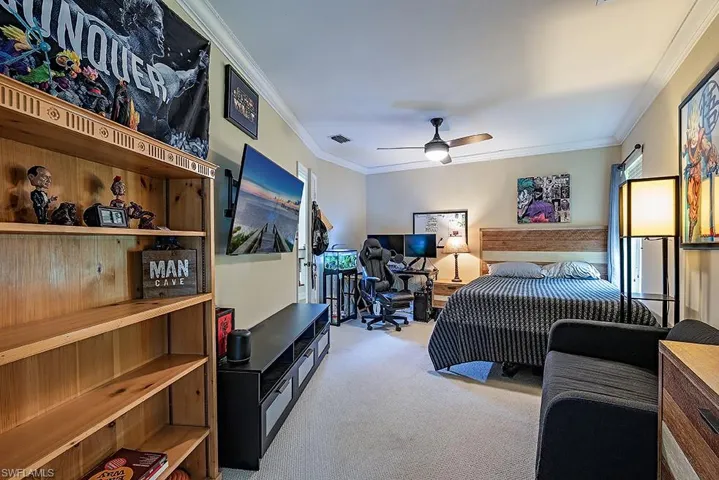 Guest Bedroom featuring crown molding, light carpet, and a ceiling fan
