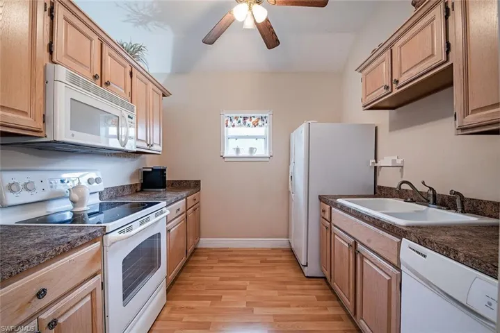 Mother-in-Law Suite Kitchen with white appliances, dark countertops, light wood-type flooring, and ceiling fan