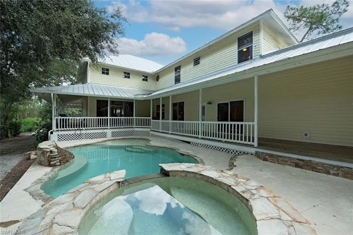 swimming pool with hot tub, a sun shelf and patio