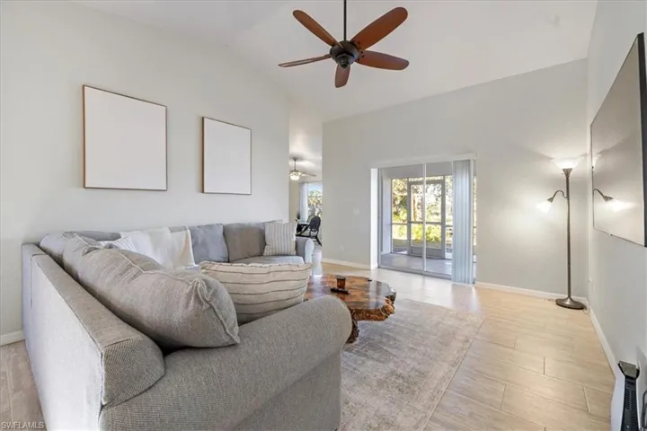 Living room featuring ceiling fan, high vaulted ceiling, and light wood-type flooring