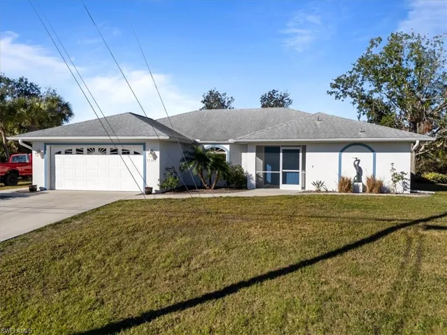 Single story home featuring a garage and a front yard