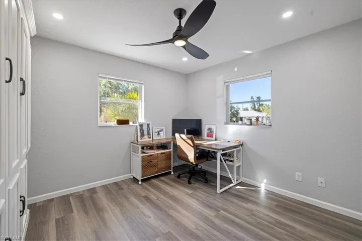Office space with hardwood / wood-style flooring and ceiling fan