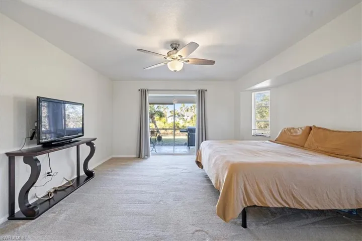 Carpeted bedroom with access to outside and ceiling fan
