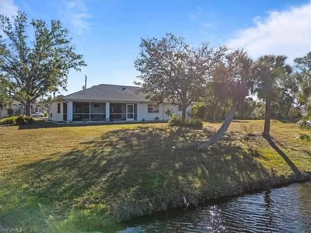 Rear view of property featuring a yard and a water view