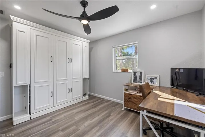 Home office featuring hardwood / wood-style flooring and ceiling fan