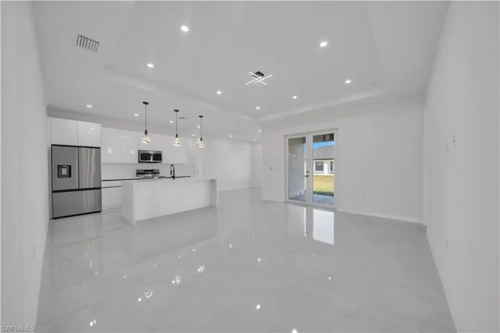 Unfurnished living room with recessed lighting and baseboards