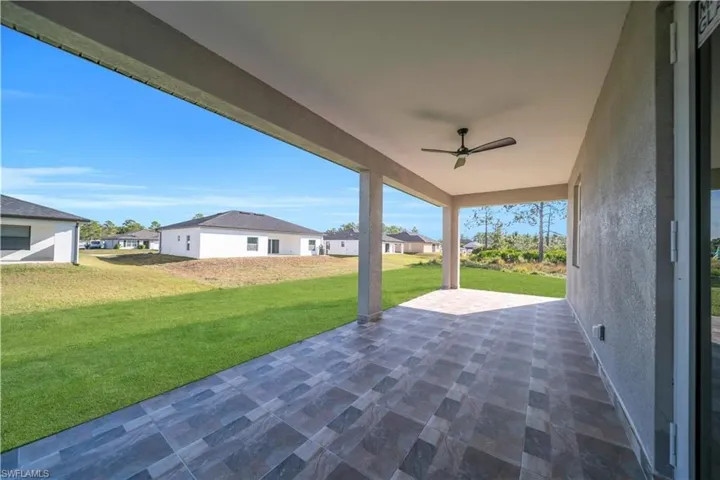 View of patio with a residential view and a ceiling fan