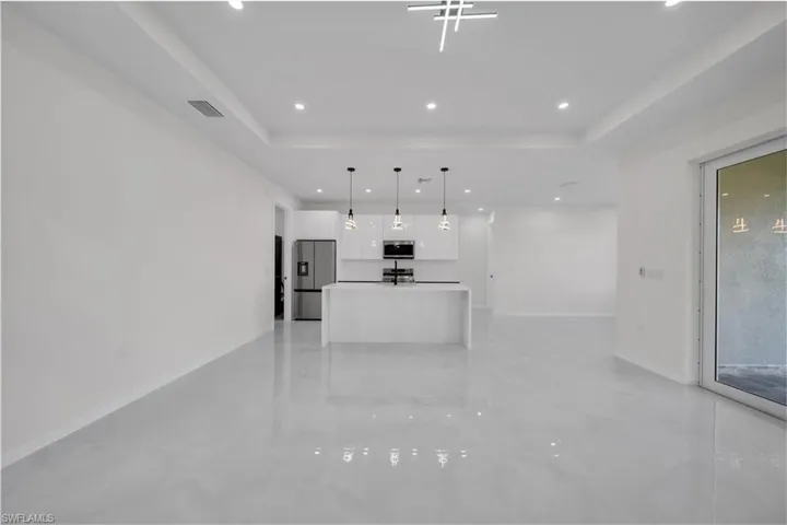 Unfurnished living room with recessed lighting and a tray ceiling