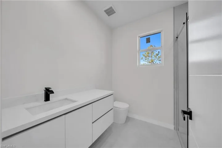 Bathroom with vanity, a shower stall, and finished concrete flooring