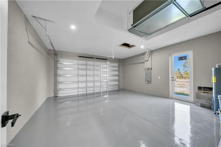 Garage featuring water heater and electric panel