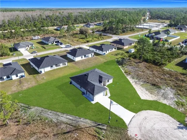 Aerial perspective of suburban area featuring a heavily wooded area