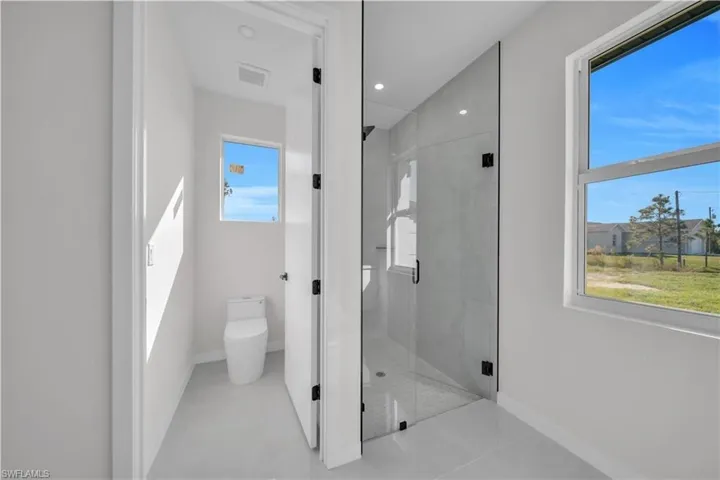 Full bath featuring a shower stall, light tile patterned floors, and recessed lighting