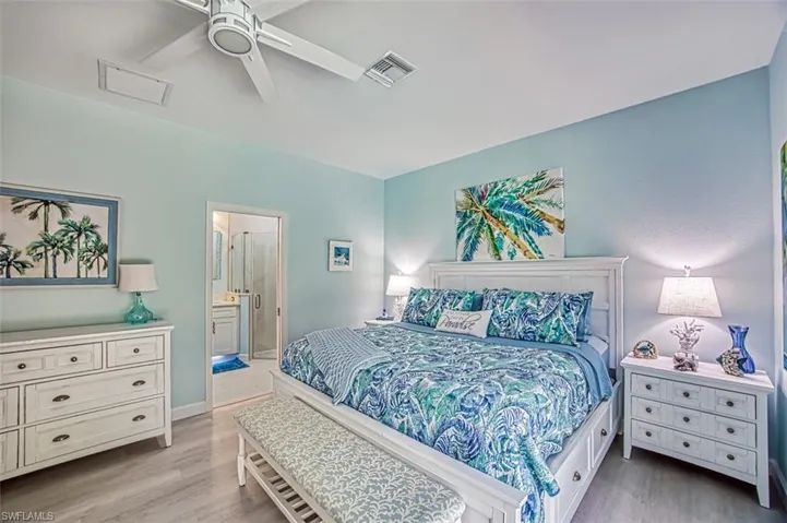 Bedroom with light hardwood / wood-style flooring, ceiling fan, and ensuite bathroom