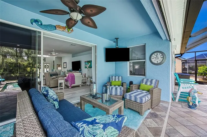 View of patio with glass enclosure, ceiling fan, and an outdoor hangout area