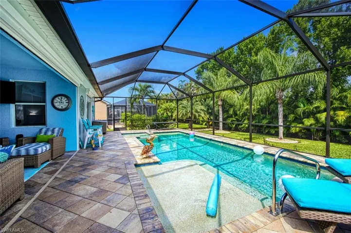 View of swimming pool featuring glass enclosure and a patio area