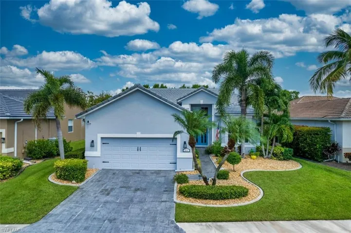 Ranch-style house featuring a garage and a front lawn