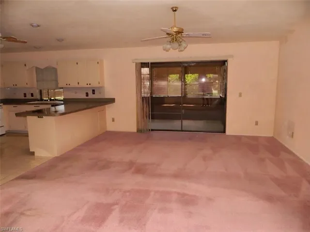 Spacious open-concept living area featuring wall-to-wall carpeting, recessed lighting, and a ceiling fan