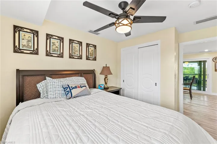 Guest Bedroom with ceiling fan, a closet, and wood finished floors