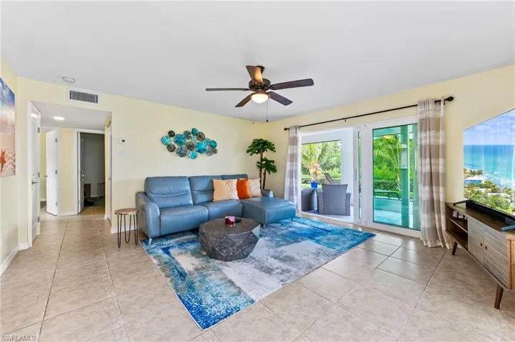 Living room of the separate guest/rental apartment on lower floor featuring a ceiling fan and light tile patterned flooring