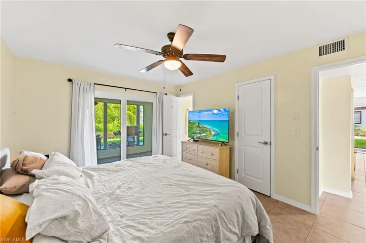 Lower Level Master Bedroom with awesome bay view, access to outside, ceiling fan, and light tile patterned floors