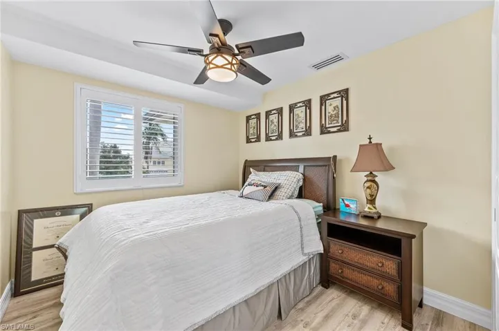 Guest Bedroom with a ceiling fan and light wood-style flooring