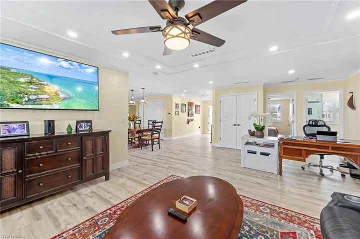 Open-style living area with light wood-style flooring, a desk, recessed lighting, and a ceiling fan