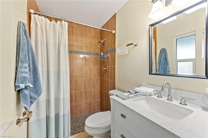 Ensuite full master bathroom at lower level with vanity and a tile shower