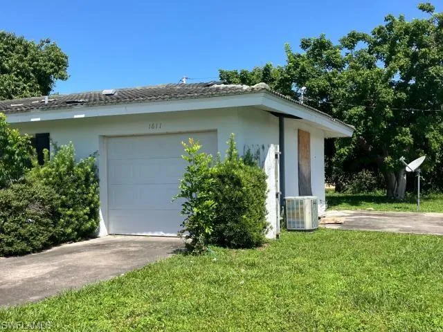 View of side of home featuring central air condition unit and a lawn
