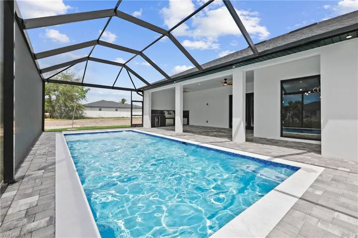 View of swimming pool featuring a sunroom, a patio area, ceiling fan, and a lanai