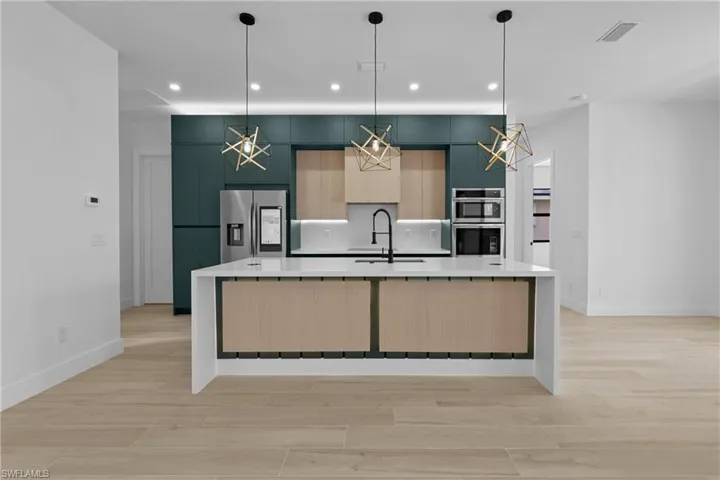 Kitchen featuring light brown cabinets, stainless steel appliances, light wood-style floors, a spacious island, and recessed lighting