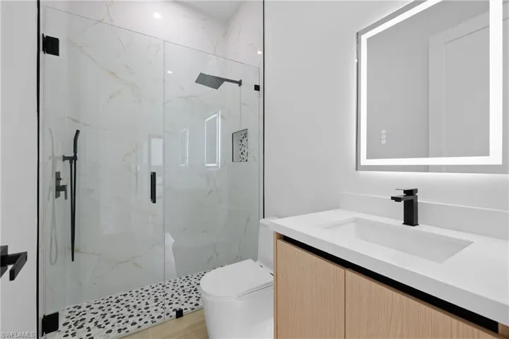 Full bathroom featuring vanity and a marble finish shower
