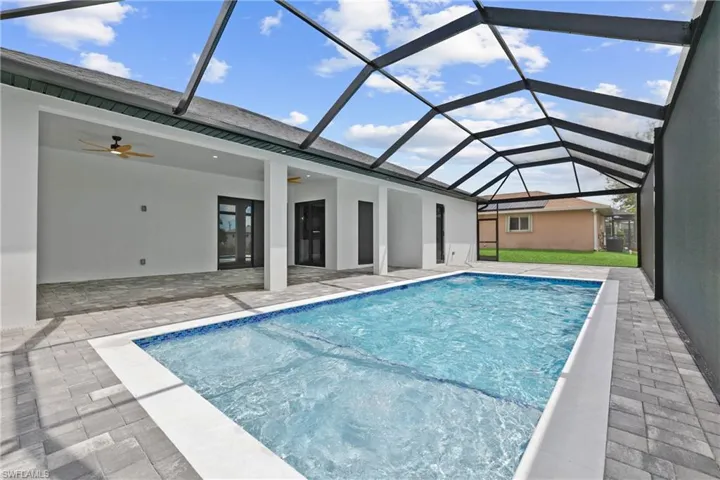 Swimming pool with a sunroom, ceiling fan, a patio, and a lanai