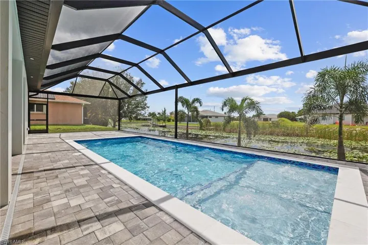 Swimming pool with a sunroom, a lanai, and a patio area