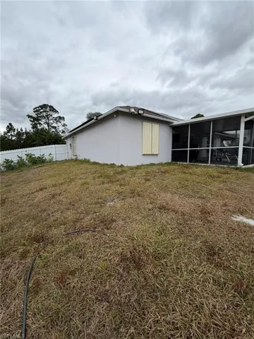 View of side of home with a sunroom and stucco siding