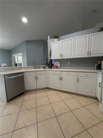 Kitchen with white cabinetry, light countertops, stainless steel dishwasher, recessed lighting, and light tile patterned flooring