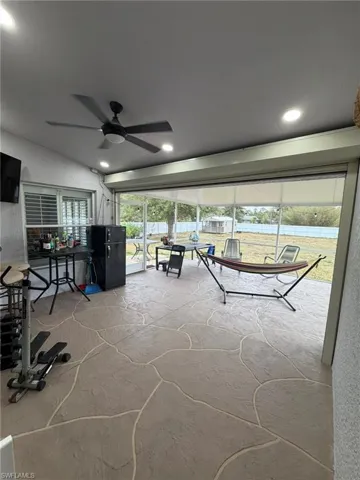 Game room with stone flooring, recessed lighting, a textured wall, and ceiling fan