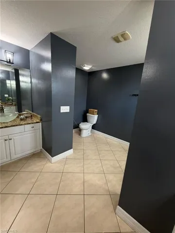 Bathroom featuring light tile patterned floors, a textured ceiling, and vanity