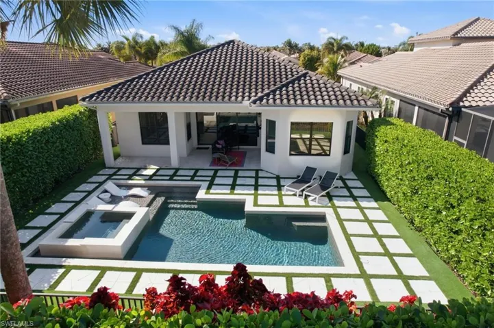 Back of property with a patio, stucco siding, and a pool with connected hot tub