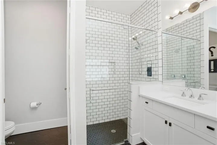 Bathroom with vanity, a stall shower, and dark tile patterned flooring